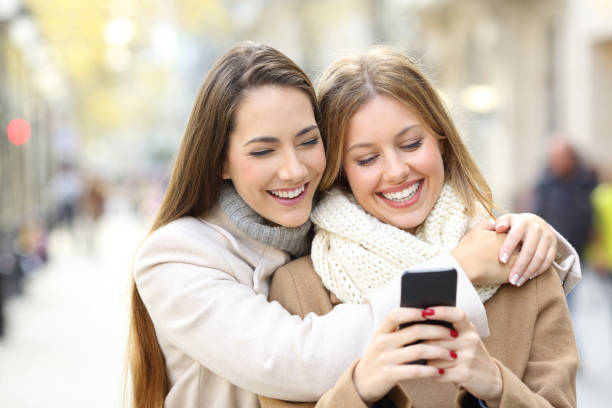 istock Two friends watching smart phone content in winter 892039236