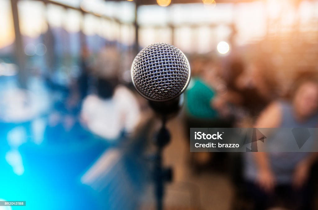 Microfono davanti a un pubblico fuori fuoco - Foto stock royalty-free di Microfono
