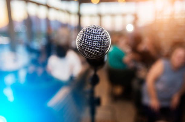 Microphone infront of an out of focus audience stock photo