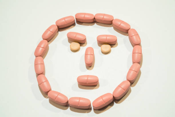 istock Pills. Tablets lined in the form of a face 892043190