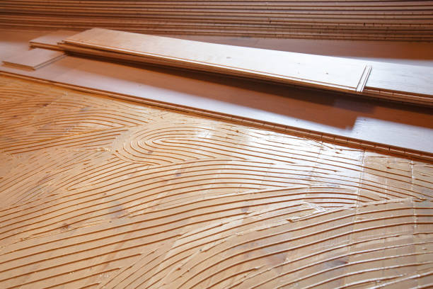 istock Adhesive primer spread, parquet laying in progress 892046686