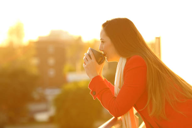 istock Profile of a woman drinking coffee in winter 892053648