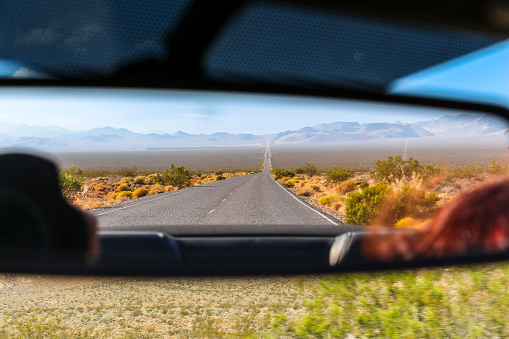 Rear mirror view on desert landscape in Nevada