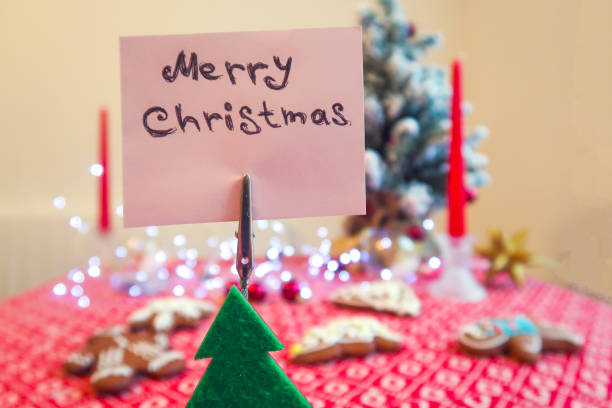 istock Note card with Christmas on top of a toy tree 892065138