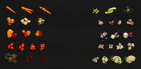 Collage of assorted vegetables isolated on black background. Whole and cut cooking ingredients for sald or soup. Vegetarian food, vitamins and eating right concept, top view, copy space