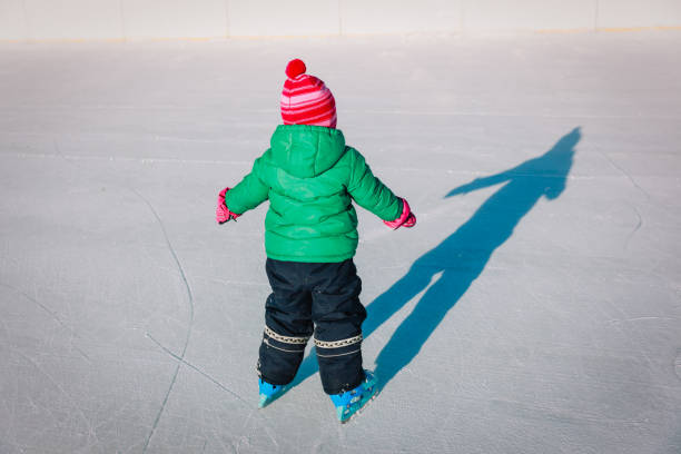 istock little girl learning to skate in winter 892080686