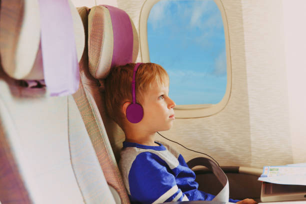 istock little boy watching tv in flight 892083424