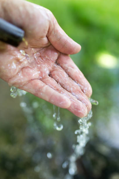 istock hand in tap water in nature 892083912