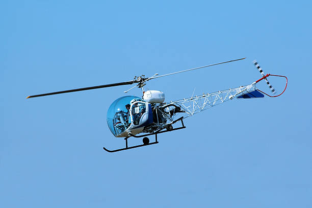 istock fishbowl canopy helicopter Bell 47G flying in blue sky 89208583