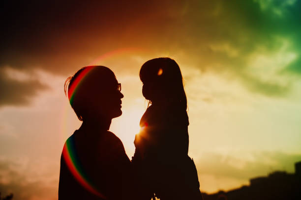 istock Father and little daughter silhouettes at sunset 892088724