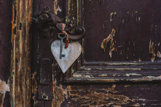istock Wooden heart with a key on the rustic door 892088978