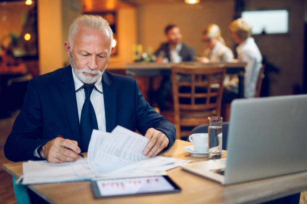 istock Senior businessman in an internet cafe working 892089370