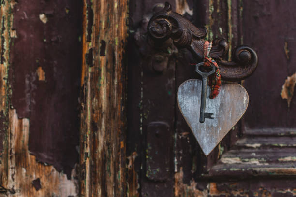 House key on a house shaped silver keyring in the lock of a door