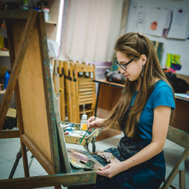 istock Artist painting a picture in a studio 892095780