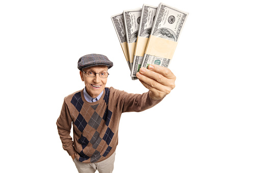 Elderly man showing bundles of money isolated on white background