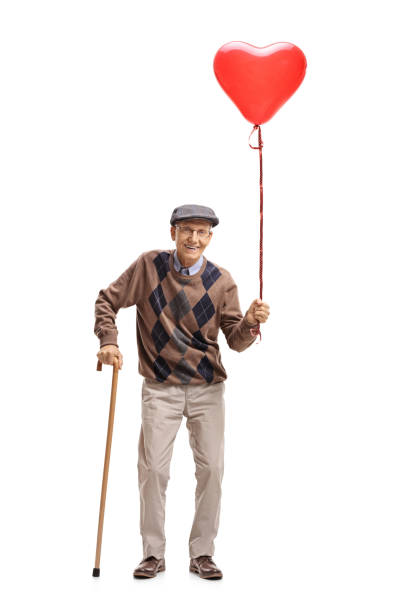 istock Senior with a heart shaped balloon and a cane 892105224