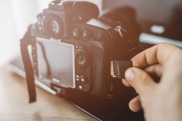 istock Male hand inserting memory card to dslr camera 892105346