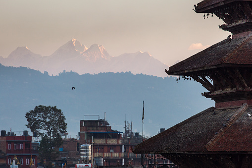 View of Nyatapola Temple in Bhaktapur, Nepal at sunrise with Himalaya mountains in background.