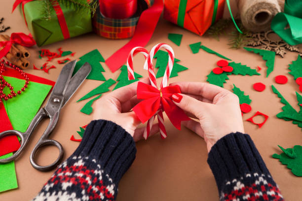 istock Creative diy hobby. Handmade craft christmas decoration, Christmas candy canes with red bow 892109318