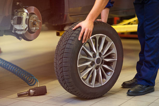 istock Car mechanic in workshop changing tires 892109776