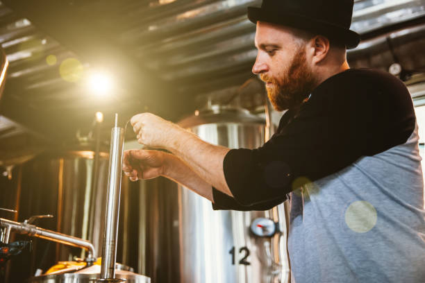 istock Male worker operating machinery in brewery 892114188