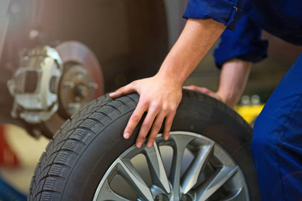 istock Car mechanic in workshop changing tires 892114422