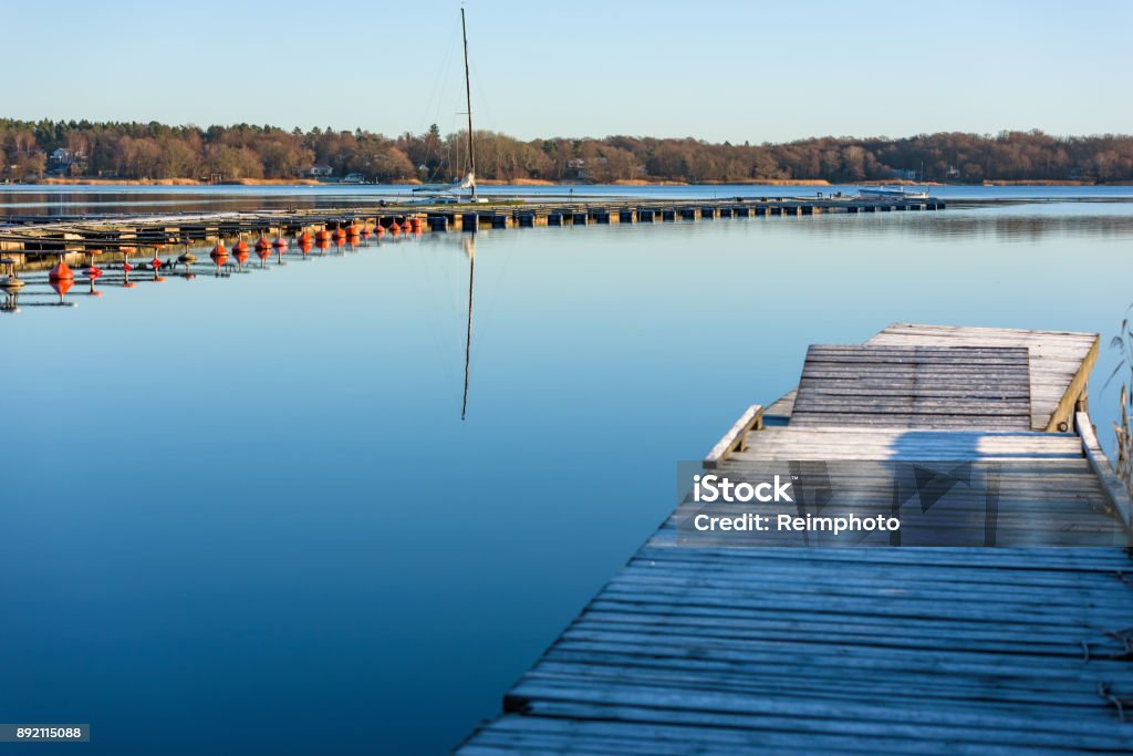 Marina and pier Empty marina and frost covered wooden pier in coastal landscape. Location Nattraby, Karlskrona, Sweden. Autumn Stock Photo