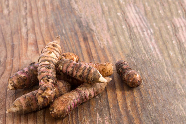 istock jerusalem artichoke on a wooden table. Selective focus 892117726