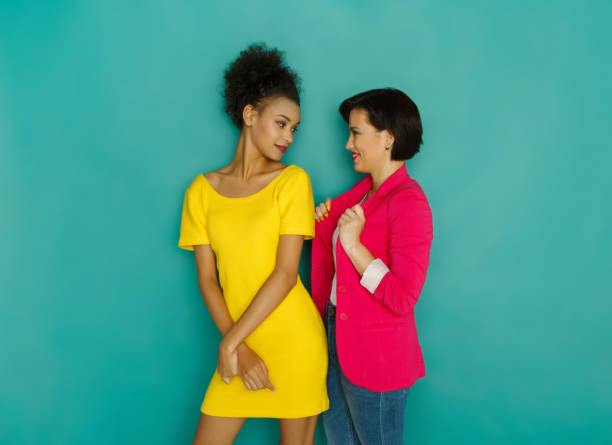 istock Girlfriends looking at each other at turquoise studio background 892117852