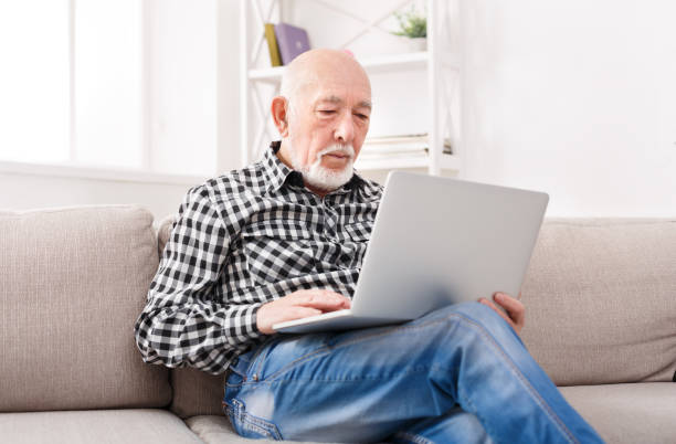 istock Thoughtful senior man reading news on laptop 892125382