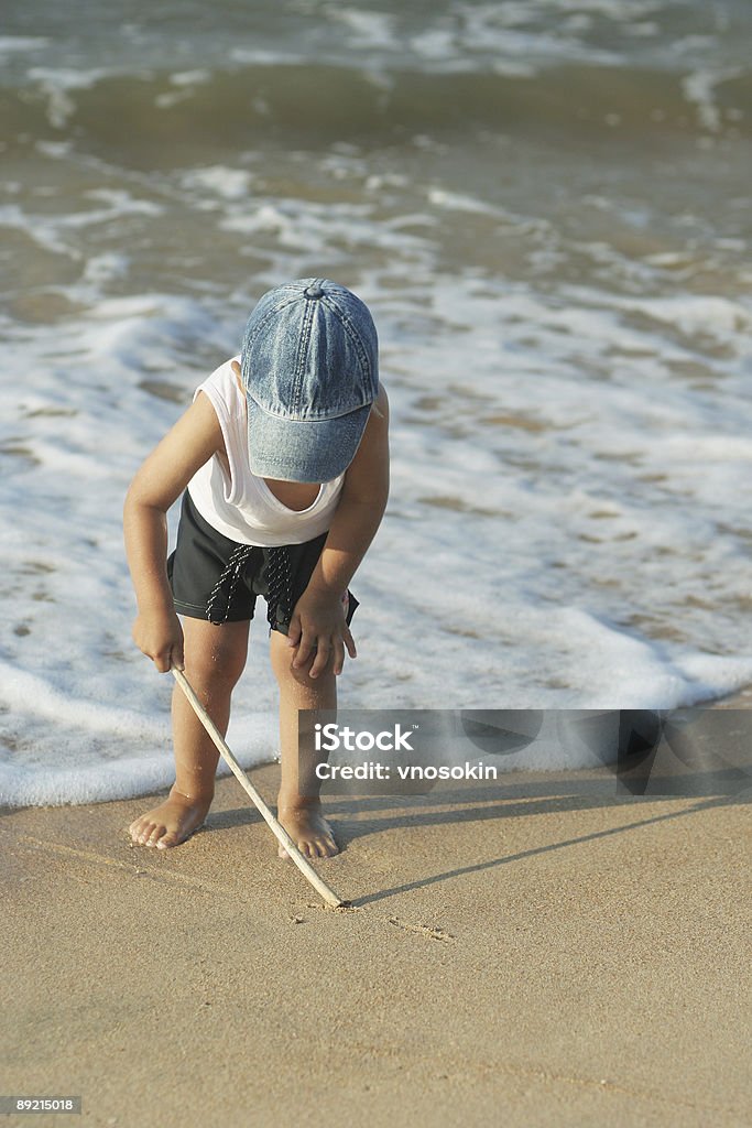 Enfant dessine sur la plage - Photo de Plage libre de droits