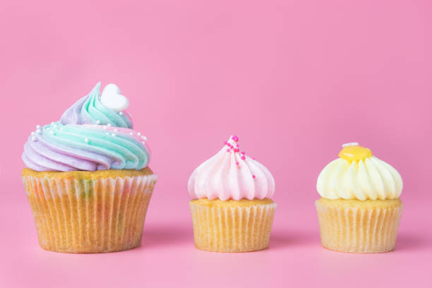 istock Rainbow pastel cupcakes and mini cupcakes on pink background 892183272