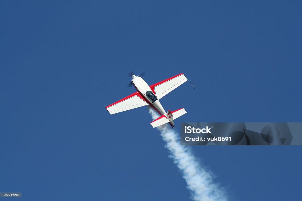 Samolot na niebieski niebo - Zbiór zdjęć royalty-free (Akrobacja lotnicza)
