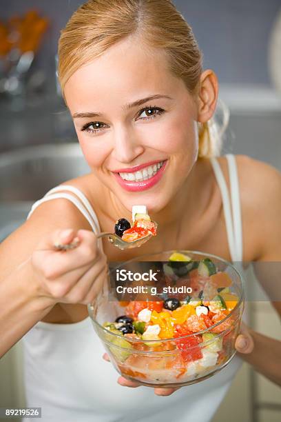 Young Healthy Woman Eating Salad In The Kitchen Stock Photo - Download Image Now - Adult, Adults Only, Beautiful People