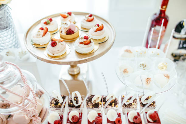 istock Delicious wedding reception candy bar dessert table full with cakes and sweets and a flower vase with hydrangeas on the background of an exquisite restaurant. 892196262