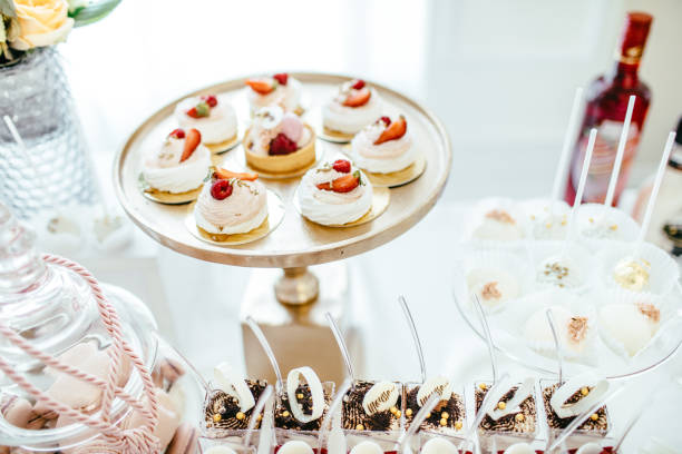 istock Delicious wedding reception candy bar dessert table full with cakes and sweets and a flower vase with hydrangeas on the background of an exquisite restaurant. 892196276