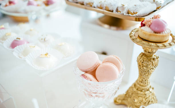 istock Delicious wedding reception candy bar dessert table full with cakes and sweets and a flower vase with hydrangeas on the background of an exquisite restaurant. 892196278