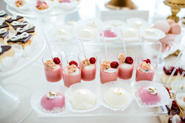 istock Delicious wedding reception candy bar dessert table full with cakes and sweets and a flower vase with hydrangeas on the background of an exquisite restaurant. 892196492