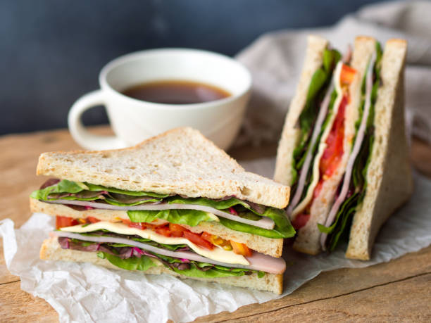 Ham cheese sandwich and coffee cup for breakfast. Homemade ham cheese sandwich with fresh tomato and lettuce for breakfast. big coffee cup stock pictures, royalty-free photos & images
