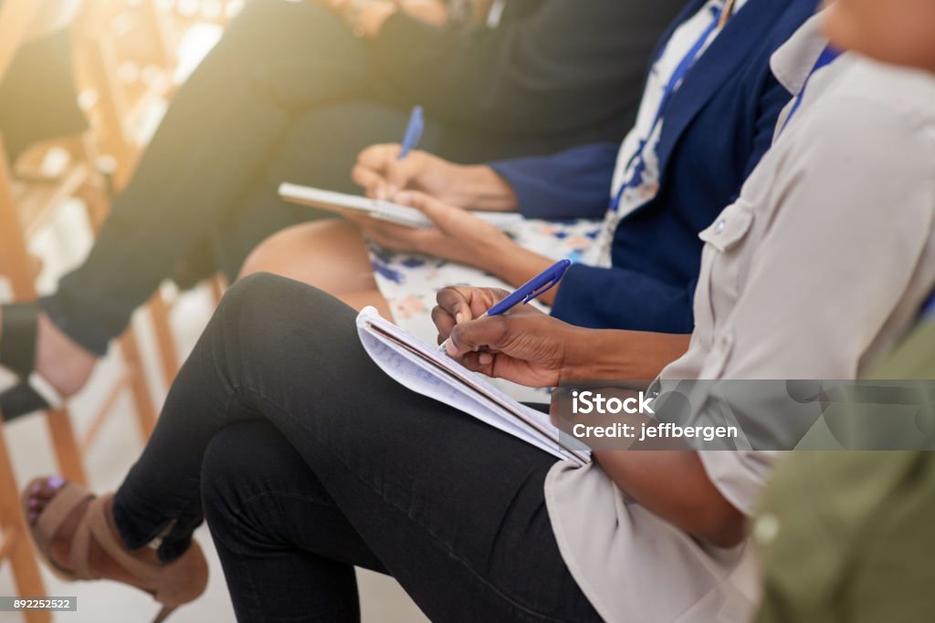 Taking down notes to take back with them Cropped shot of audience members making notes on their notepads at a conference Education Training Class Stock Photo