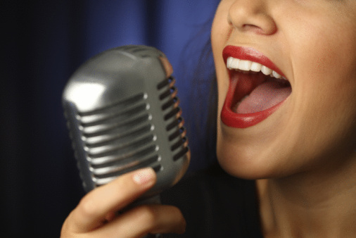 Close up of woman singing into vintage microphone