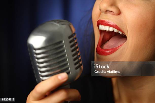 A Closeup Of A Vintage Microphone With A Singing Woman Stock Photo - Download Image Now