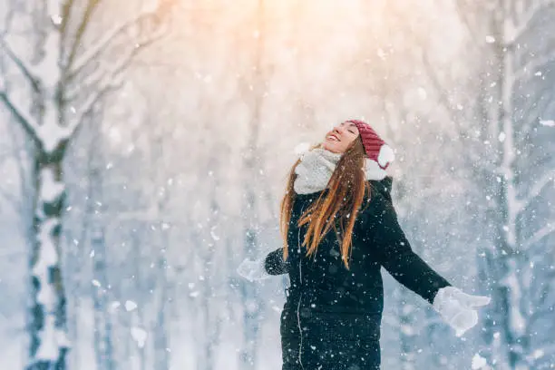 Photo of Winter young woman portrait. Beauty Joyful Model Girl laughing and having fun in winter park. Beautiful young woman outdoors. Enjoying nature, wintertime