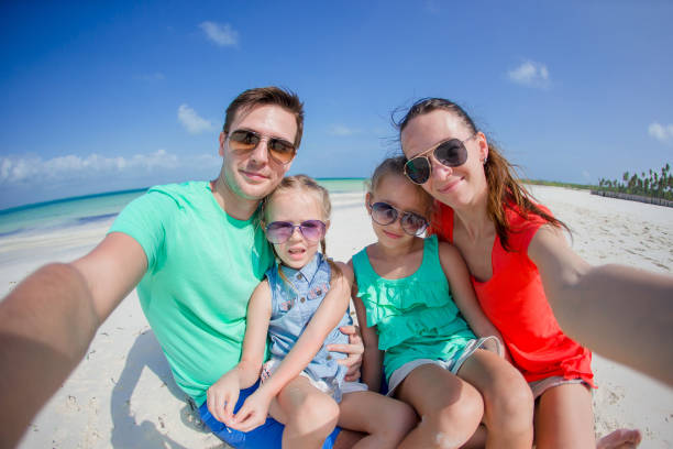 istock Young beautiful family taking selfie on the beach 892261150