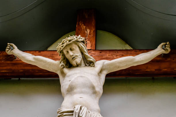 eine statue von jesus am kreuz aus holz geschnitzt und bemalt - cross nail wood resurrection stock-fotos und bilder