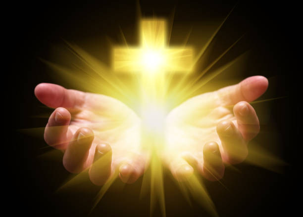 istock Hands cupped and holding or showing Cross or Crucifix with bright, glowing, shining light. 892273152