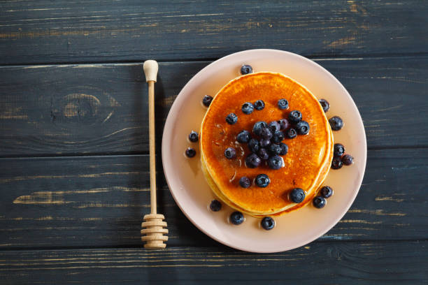 istock Pancakes with honey and blueberries on wooden table 892277540