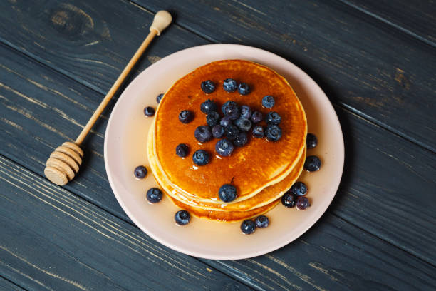 istock Pancakes with honey and blueberries on wooden table 892277710