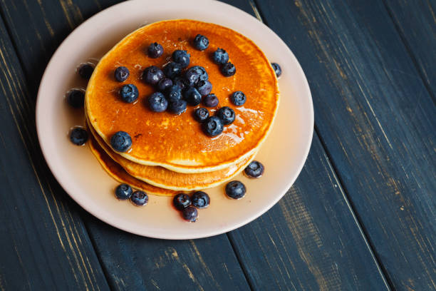 istock Pancakes with honey and blueberries on wooden table 892277758