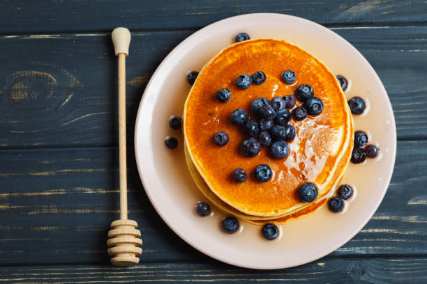 istock Pancakes with honey and blueberries on wooden table 892277860
